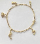 PULSEIRA COM BERLOQUE CONFECCIONADO EM OURO AMARELO 18K 750, COM PINGENTES DE GOLFINHOS, ELEFANTE, FIGA E SACO DE DINHEIRO, TAMANHO: 18, PESO: 6,9g, VALOR DE MERCADO: R$ 4.200,00