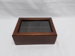 Caixa retangular em madeira com 6 divisões internas e vidro na tampa. Medindo 25cm x 19,5cm x 9,5cm de altura.