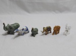 Lote de 6 enfeites na forma de elefante, sendo 3 em porcelana, 1 em resina, 1 em madeira e 1 em vidro (com restauro). Medindo o maior em porcelana 8cm de altura.