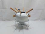 Pequena panela de fondue com rechaud e 6 garfinhos em metal esmaltado com fundo antiaderente. Medindo a panela 17cm de diâmetro x 8cm de altura.
