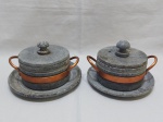 Par de pequenas caçarolas em pedra com alça em cobre e pratos de apoio. Medindo 13cm de diâmetro x 6,5cm de altura.