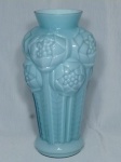 Antigo vaso em vidro opalinado na cor azul claro, estilo Art Déco, bojo decorado com flores e folhagens em alto relevo. Borda com pequeno lascado. Med. 26 x 14cm.