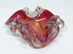 Cinzeiro em grosso vidro de Murano na cor vermelha, década de 50, moldado em ondulados. Pequeno bicado na borda., Med. 6 x 15 x 15cm.