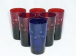 Seis copos altos em cristal europeu decorados com ramos de oliveira, sendo 5 na cor vermelho rubi e 1 na cor azul cobalto. 1 vermelho e 1 azul com pequeno bicado na borda. Alt. 14cm.