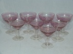 Oito taças em vidro translúcido rosa, corpo com lapidação oval. 1 com pequenos bicados na base e 1 com pequeno bicado na borda. Med. 11,5 x 9,5cm.
