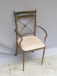 Cadeira em metal pintado de dourado, pés palito, braços curvos, assento removível estofado na cor branca, encosto vasado em "X". Alt. 87cm.