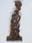 Escultura em madeira entalhada representando figura indígena segurando uma cobra pela cabeça com a mão esquerda. Na mão direita uma lança. Assinada "Art Vicent Jequitinhonha M.G - Jun. 07". Lança quebrada. Alt. 40cm.