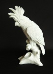 Grande grupo escultórico representando ave sobre galho, confeccionado em material sintético. Medida 34 cm de altura.