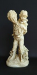 Grande grupo escultórico representando crianças tendo na base florais e cão, confeccionada em material sintético . Medida 40 cm de altura.