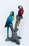 Escultura de duas araras repousando sobre o tronco, em resina de qualidade. Med. 23x13 cm.
