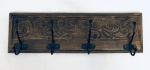 Cabideiro em madeira nobre, decorado com entalhes de arabescos, com quatro ganchos em ferro. Med. 45,5x13,5 cm.