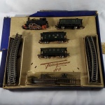 FERROMODELISMO - BRINQUEDO ANTIGO - TREM ELÉTRICO FLEISCHMANN HO - Fabricado na Alemanha (FLEISCHMANN DB #891315), na Caixa Original com danos do tempo, composto de Locomotiva, 03 Vagões e Trilhos. Na tampa da caixa seu antigo proprietário colou fitas adesivas. Não temos o transformador, razão pela qual não foi testado. Manualmente todas as rodas giram normalmente. O aspecto das peças é muito bom, ou seja, muito bem conservadas.