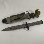 MILITARIA - FACÃO BAIONETA na cor cinza, com bainha. Mede sem a bainha aprox. 32,7 cm. Com a bainha mede aprox. 36,5 cm.