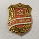 42. Militaria. Belo Distintivo em metal da POLÍCIA VOLUNTÁRIA DA URSS, com imagem de foice e martelo. A peça traz a marca do fabricante no verso.