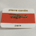 PIN formato de HELICÓPTERO. Na cartela Pierre Cardin. Ausência do prendedor.