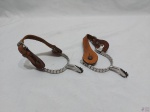 Par de esporas em metal prateado com fechadura em couro. Medindo 13cm de comprimento x 8cm de abertura