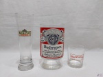 Lote de 3 copos em vidro, sendo 2 de cerveja e uma de vodka, com propaganda. Medindo a maior 20cm de altura.