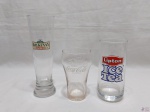 Lote de 3 copos em vidro, sendo um de cerveja, um da Coca Cola e um do Lipton, com propaganda. Medindo a maior 20cm de altura.