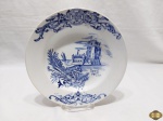 Prato decorativo em porcelana portuguesa com pintura de castelo. Medindo 23,5cm de diâmetro. Com bicado na borda.