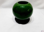 Vaso em porcelana verde com peanha em madeira entalhada. Medindo o vaso 16,5cm de diâmetro de bojo x 17cm de altura com peanha.