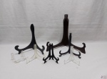 Lote composto de 7 suportes de mesa para pratos decorativos. Materiais diversos. Medindo o suporte maior em madeira 27cm de altura.