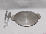 Prato de bolo com 2 alças em aço inox, facão e espátula em aço inox com pega em acrílico. Medindo o prato 31cm de diâmetro.
