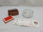 Lote composto de par de baralhos em papel, estojo para baralhos em madeira e cinzeiro em vidro lapidado. Medindo o cinzeiro cm x14cm de diâmetro x 6cm de altura. Cinzeiro com leve bicado.