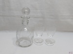Lote composto de garrafa licoreira com 2 taças de aperitivo em cristal lapidado. Medindo a licoreira 28cm de altura.