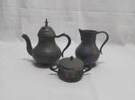 Lote composto de bule, leiteira em estanho e manteigueira em prata 90. Medindo o bule 18cm de altura.