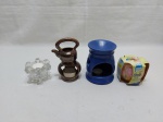Lote de 3 castiçais, sendo 2 em porcelana e 1 em vidro moldado, e uma vela aromatizante com castiçal em vidro. Medindo o castiçal azul 12,5cm de altura.