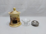 Lote de 3 castiçais, sendo um em metal, um em vidro e um em porcelana. Medindo o castiçal de porcelana (leve fio de cabelo na borda 13,5cm de diâmetro x 14,5cm de altura.