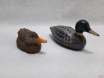 Lote de 2 enfeites na forma de pato, sendo um em resina e um em metal pintado. Medindo o maior em metal 16,5cm de comprimento x 7,5cm de altura.