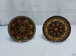 Lote de 2 pratos decorativos em metal esmaltado. Medindo 19cm de diâmetro.
