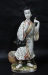 ESCULTURAS - Escultura em porcelana chinesa vitrificada branca, representando figura de "gueixa", rica em detalhes, marcada no fundo. Medidas alt 27 cm x comp da base 12 cm x larg da base 9 cm. Com um colado no dedo da mão direita.