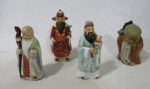 ESCULTURAS - Quatro esculturas em porcelana oriental policromada, representando figuras de "sábios chineses". Medidas do maior alt 11,5 cm; medidas do menor alt 9 cm.