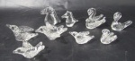 CRISTAIS - Lote contendo nove peças decorativas em miniaturas, confeccionadas em cristal translúcido, sendo quatro pássaros, dois cavalos, e três cisnes. Medidas da maior alt 6 cm x comp 5 cm; medidas da menor alt 2,5 cm x comp 5,5 cm.