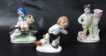 PORCELANA - Lote contendo três esculturas em miniaturas, confeccionadas em porcelana vitrificada branca, sendo uma floreira, uma reapresentando menino com cachorro e uma representando menina sentada segurando cesto e olhando para o cachorro. Medidas da maior alt 9,5 cm x comp 6 cm x larg 3,5 cm; medidas da menor alt 8,5 cm x comp 5,5 cm x larg 2,5 cm.