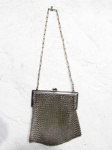 ACESSÓRIOS FEMININOS - Uma (1) bolsa feminina em ALPACCA anos 20, confeccionada  malha de metal prateado, maleável, fecho com dois ganchos finalizados em bola, parte superior em metal cinzelado, alça em corrente. Medidas: 12,5 cm de altura x 10 cm de largura.