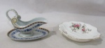 PORCELANA - Lote contendo duas peças em porcelana, sendo A: uma molheira com presentoir em porcelana portuguesa esmaltada, manufaturada VISTA ALEGRE PORTUGAL, decorada com motivos vegetalistas nas tonalidades azul e vasta douração, alça trabalhada finalizando em volutas, medindo: alt total 8,5 cm x larg total 12 cm; B: uma petisqueira em porcelana vitrificada branca, da manufatura ROYAL ALBERT BONE CHINA ENGLAND, moldada em formato de concha, decorada com elementos vegetalistas em rica policromia, bordas recortadas e filetadas a ouro. Peças marcadas no fundo.