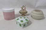 DIVERSOS - Lote com o total de quatro caixas porta joias, contendo A: duas em porcelana esmaltada nas tonalidades branca, rosa e verde, da manufatura Schmidt, decoradas com motivos vegetalistas e frutos, sendo uma em formato de coração, marcadas no fundo; B: uma em resina, ricamente trabalhada e policromada, com tampa encimada com esculturas representando "casal em cortejo"; C: uma em porcelana portuguesa, manufaturada IBIS AVEIRO, decorada com elementos vegetalistas, frutos e pássaros em rica policromia, marcada no fundo. Medidas: maior alt 8 cm x diam da borda 8 cm/ menor: alt 4 cm x larg 7 cm. Uma caixa possui um bicado na borda.