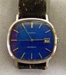 RELÓGIO, um (1) antigo de pulso da marca JUVENIA (Juvenia Montres S/A, fundada em 1860, por Jacques Didisheim-Goldschmidt, em Saint Imier, Suíça; pouco tempo depois mudou-se para La Chaux-de-Fonds, Suíça; em 1988 foi vendida para Asia Commercial Holdings Ltd.), mostrador azul com datador, mecânico, automático, caixa e tampa em aço inox, medindo 34 x 32 mm, numerado 1138360, pulseira em couro com sinais de desgaste, usado, funcionando e sem garantia.