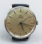 RELÓGIO, um (1) antigo de pulso, Suíço, marca UNIVERSAL GENEVE (fundada em 1894 na cidade de Le Locle, como Universal Watch; em 1919 virou Universal Geneve), caixa e tampa em metal prateado, pulseira em couro ecológico, medindo 34 mm diâmetro, usado, funcionando e sem garantia.