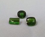 GEMAS, três (3) TURMALINAS, tonalidade verde intenso, lapidações diversas facetadas, peso total aproximado 6 carats.