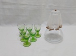Lote de moringa em vidro incolor com 6 taças de licor em vidro verde. Medindo a moringa 19,5cm de altura.