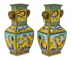 ARTE ORIENTAL - Cloisonné - Excepcionais par de antigos vasos com pegas de metal dourado na forma de cabeças de elefante. China -  Fins do Século XIX.  Marcas na base. Adornados por delicadíssima, farta e profusa decoração multicolorida, reproduzindo cenas com aves do paraíso voando e se "exibindo" em jardim paradisíaco, tendo como cor predominante o amarelo imperial, na técnica chamada "cloisonné ". Med. 31 x 15 x 11 cm . Marcas do tempo. Pequenas faltas.  Coleção Particular Rio de Janeiro.