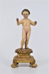 Arte Sacra - Imagem de madeira esculpida e policromada , representada pelo menino Jesus dito Colonial sobre pedestal dourado. Olhos de vidro. Acompanha caixa com 13 roupinhas de época , confeccionados em convento. Brasil - Bahia - Século XIX. Med. 26 x 11 x 11 cm (medidas totais);  10x 18 x 31 cm (caixa roupinhas). roupinhas : 10 x 15 cm (maior); 12 x 12 cm (menor). Marcas do tempo com desgastes e pequenas perdas. As roupinhas estão no estado. Coleção particular Rio de Janeiro/RJ.