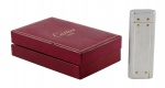 CARTIER - Elegante Isqueiro suíço de aço e ouro. Cartier - Paris. Série Santos. Nº 29318 K. Acompanha caixa original. Med. 7 x 2,5 x 10,5 (isqueiro); 10,5 x 7 x 3 cm (caixa). Isqueiro e caixa com marcas de uso e pequenos desgastes. Não testado. Acervo Particular Rio de Janeiro-RJ.