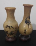 Dois pequenos vasos em pedra dura em forma de balaústre decorado com entalhes de folhagens de bambu em inscrições em chinês, assinado ideograma em vermelho. Com penha em madeira, medida total 12,5 cm