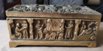 Pesada  caixa retangular  em bronze espesso,  ricamente cinzelada em relevos  com figuras em cenas Greco/Romanas. Pesando 2,6 kg e medindo 20x11x09 cm. Possui riqueza de detalhes e raro esmero