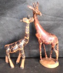 Par de girafas africanas em madeira nobre, uma delas, a maior com pequena perda na orelha. Alt. 26cm e 32cm